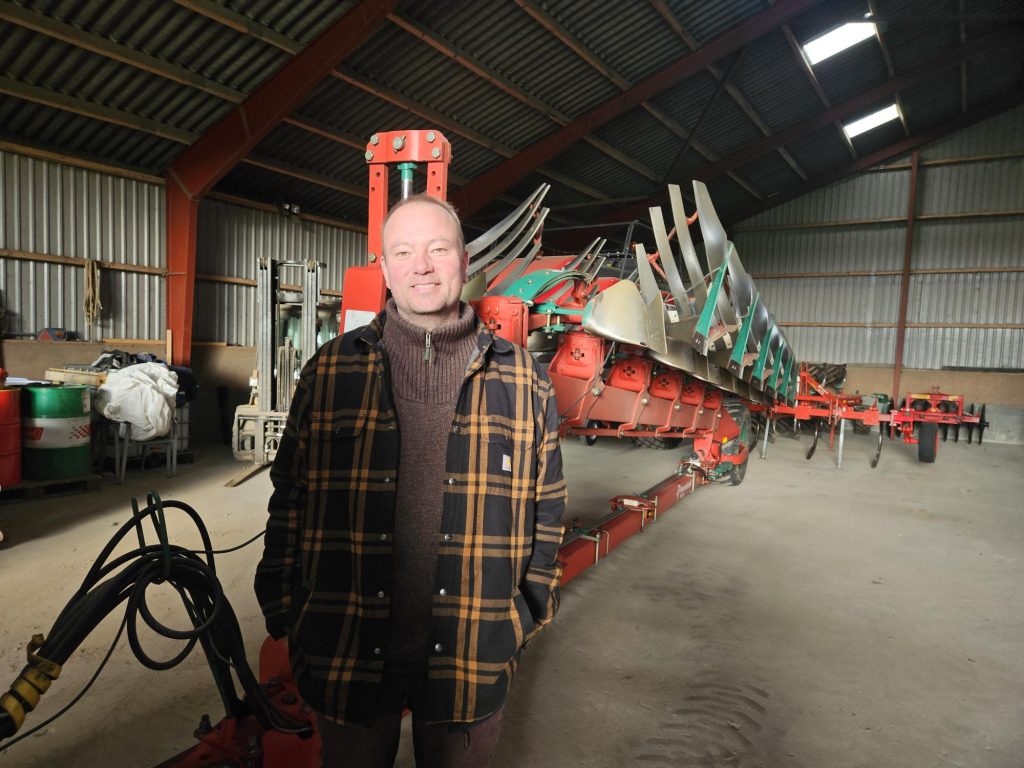 Niels Arentzen står foran en plov.